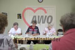 Fünf Seniorinnen sitzen um Tische herum bei Kaffee und Kuchen und blicken auf ihre Teller