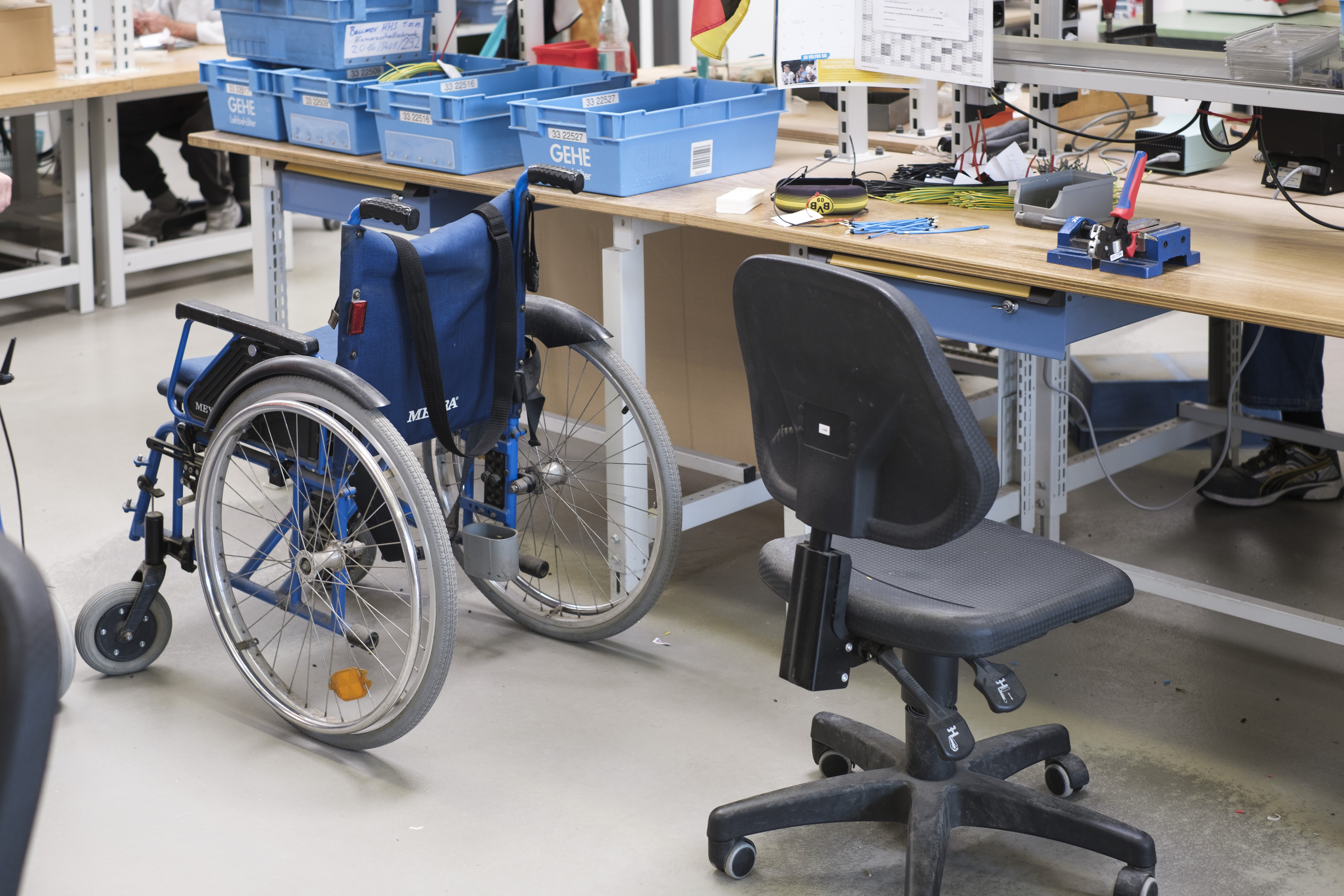 Leerer Rollstuhl neben Werkbank