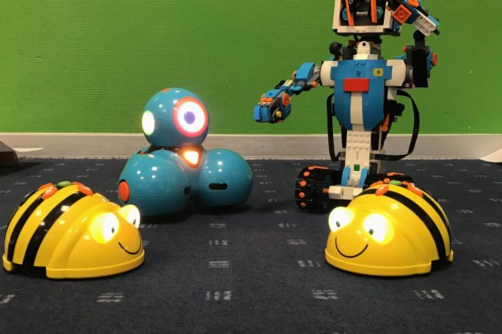 Vier kleine Modellroboter stehen nebeneinander