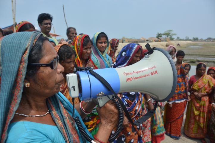 Eine Frau im Sari spricht in ein Megafon