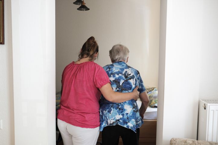 Eine Pflegerin stützt eine ältere Person beim Gehen