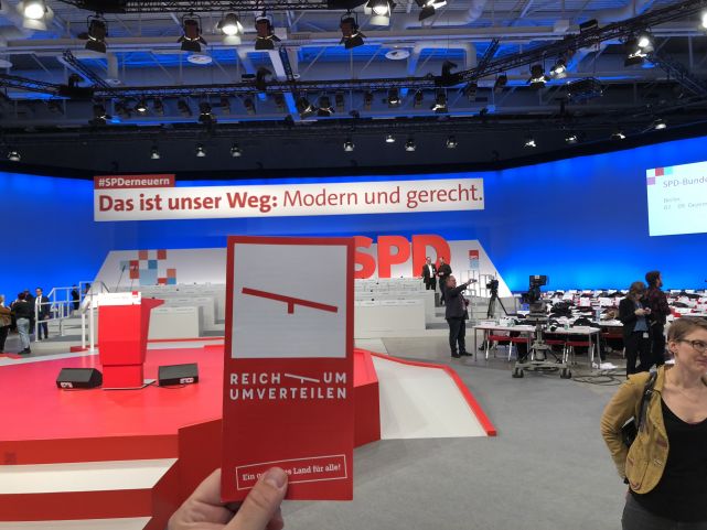 Die Karte vom Bündnis Umverteilen vor dem Slogan der SPD auf dem SPD Parteitag
