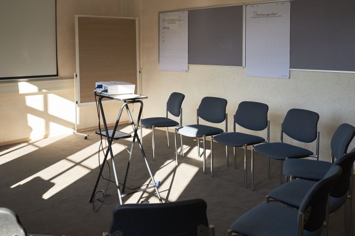 Ein Seminarraum mit Leinwand Pinnwand Tafeln Stühlen Beamer