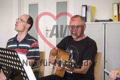 ein Mann spielt Gitarre neben ihm singt ein Mann