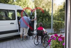 Ein Mann steht an der Beifahrertür eines Transporters für alte Menschen Seniorinnen und Senioren
