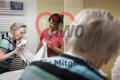 Eine Frau hilft einer alten Frau Seniorin beim Abtrocknen in einem Pflegeeinrichtung