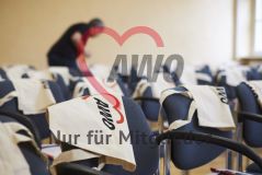 Beutel Taschen mit AWO Logo hängen über Stühlen