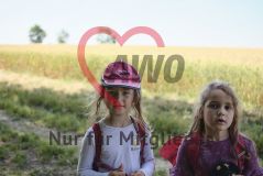 zwei Mädchen, eins davon mit AWO-Käppi, vor einem Feld