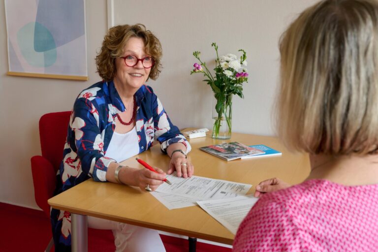 Krebsberatung der AWO in Hamburg. Zwei Frauen sitzen am Tisch und diskutieren.