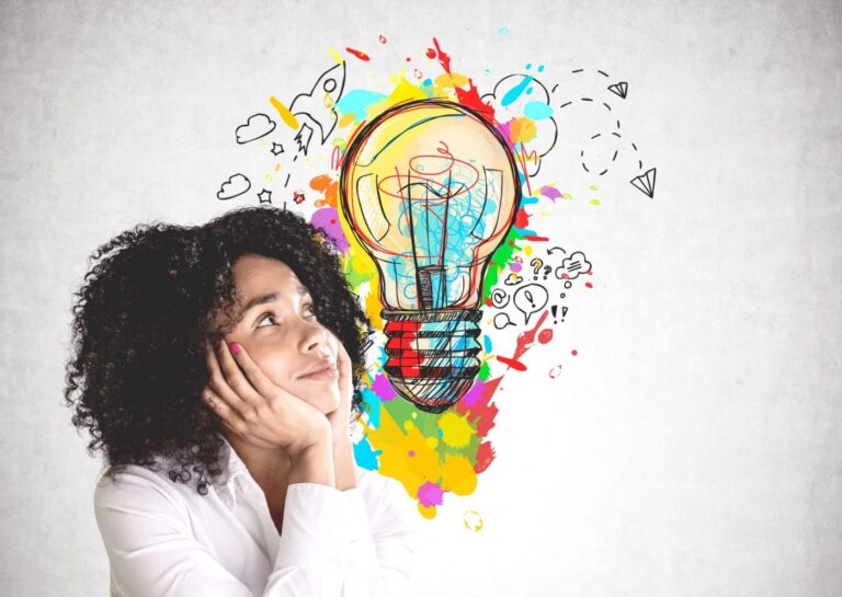Frau mit lockigem Haar, hält den kopf in Händen. Neben ihr ist die Illustration einer Glühbirne mit vielen Farben und diversen Icons.