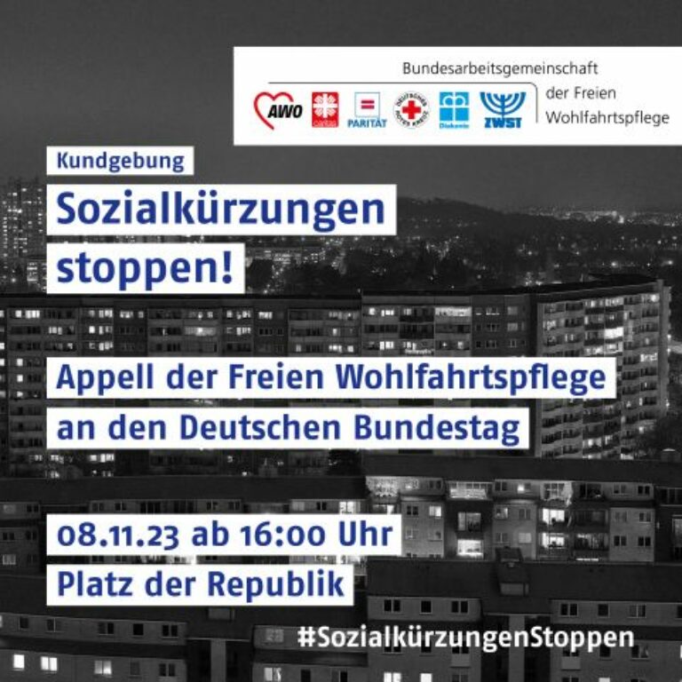Schwarz-Weiß-Foto einer Stadt. Auf dem Bild steht unter anderem "Kundgebung. Sozialkürzungen stoppen!"