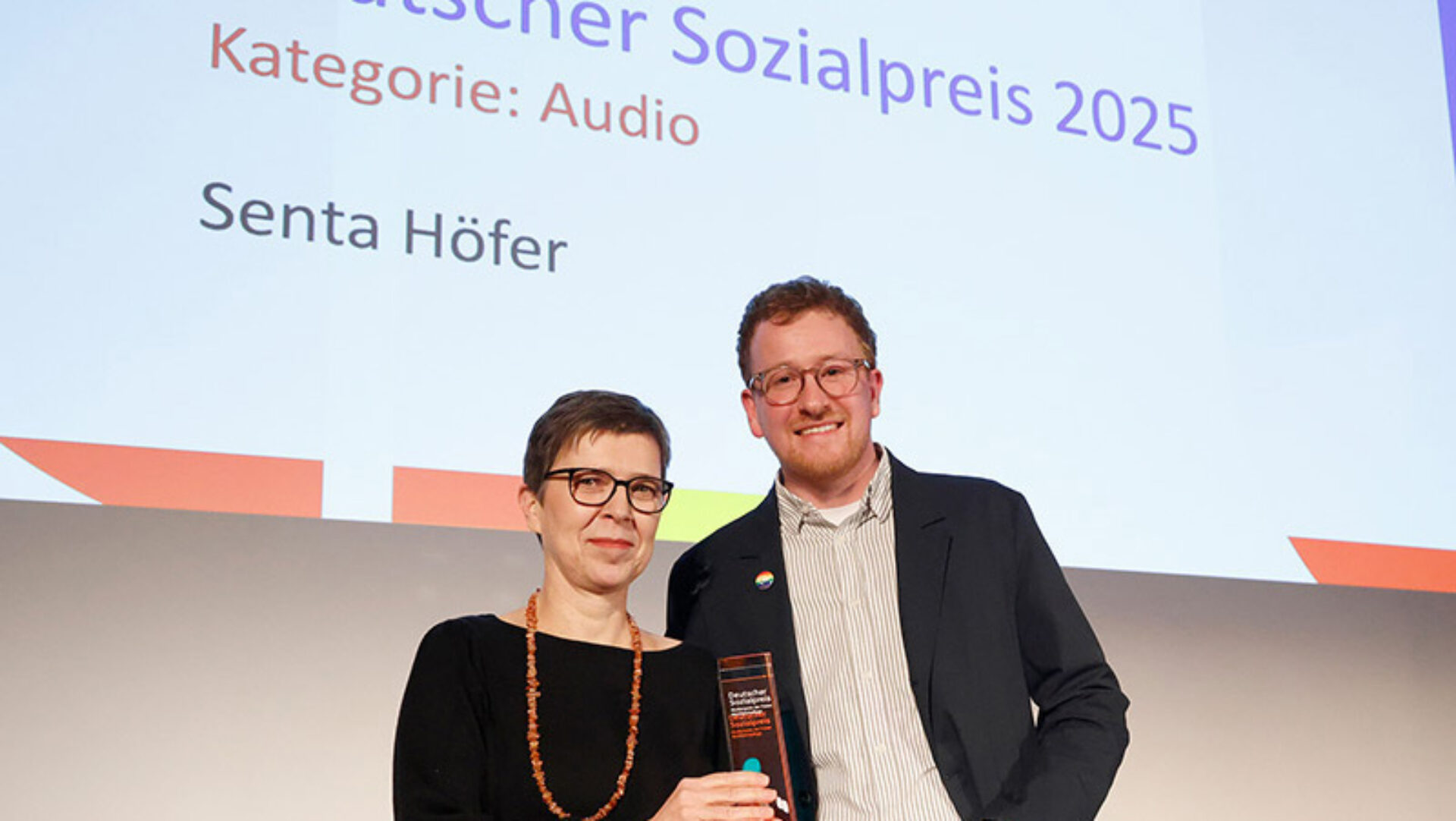 AWO-Vorstand Dr. Marvin Deversi überreicht den Deutschen Sozialpreis der Kategorie Audio an Senta Höfer.