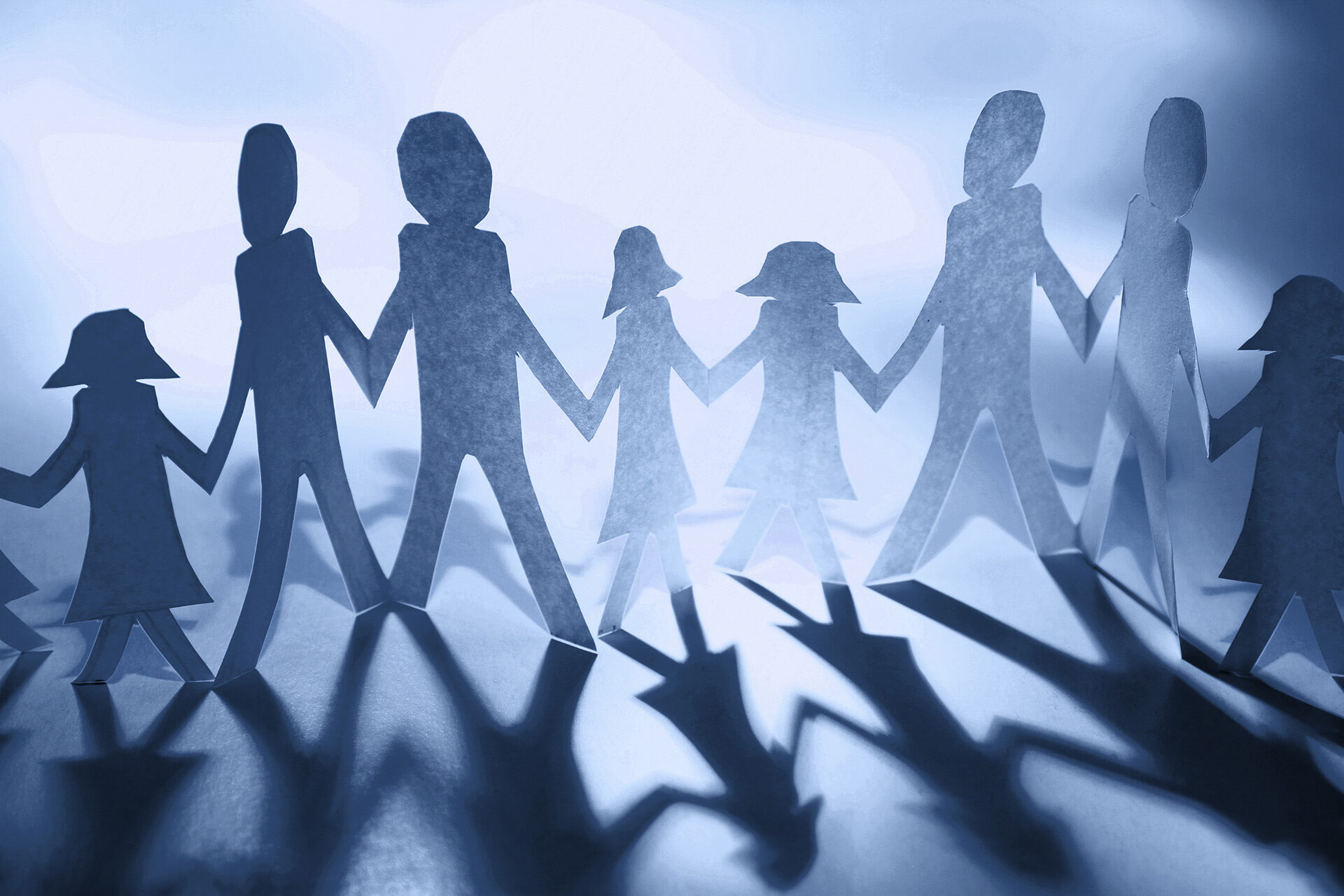 Kette aus Papierfiguren, die sich an den Händen halten