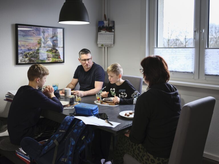 Familie mit Kindern sitzt am Esstisch
