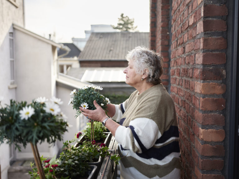 Seniorin pflegt Blumen