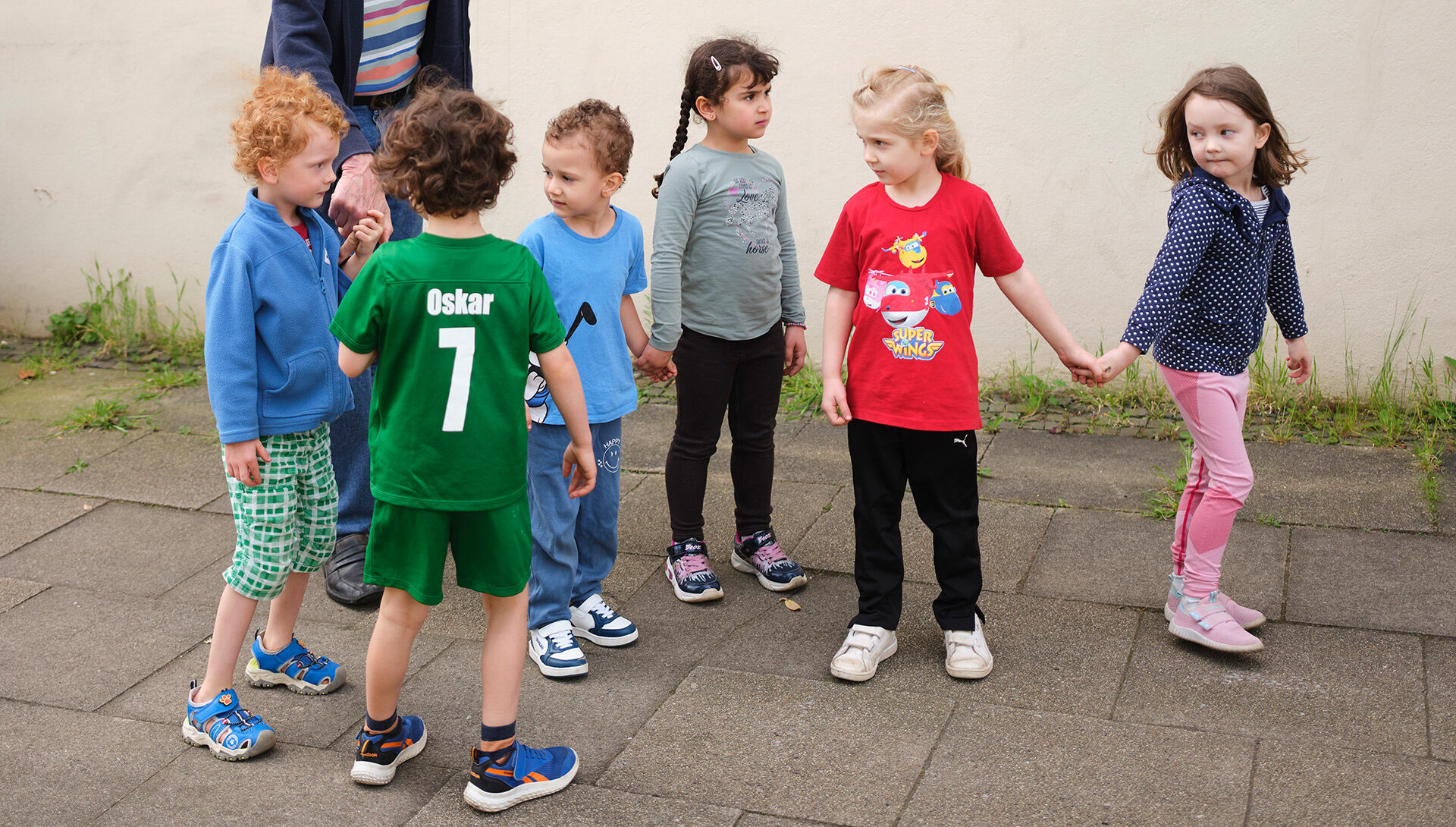 sechs Kita-Kinder, die sich an den Händen halten