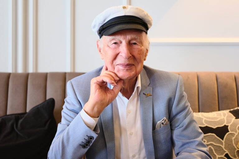 lächelnder Senior mit Kapitänsmütze