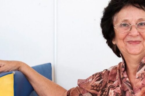 Eine Dame lehnt ihren Arm auf einem Kissen ab.