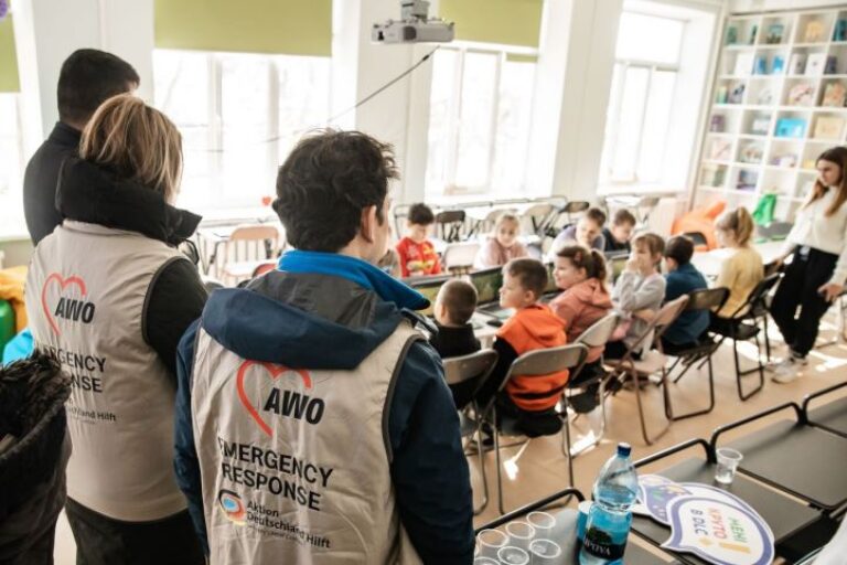 Nothlfer stehen vor einer Schulklasse