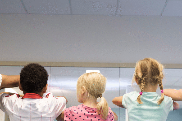 Drei Kinder stehen mit dem Rücken zur Kamera