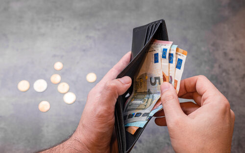 Portemonnaie mit einigen Geldscheinen in Männerhänden