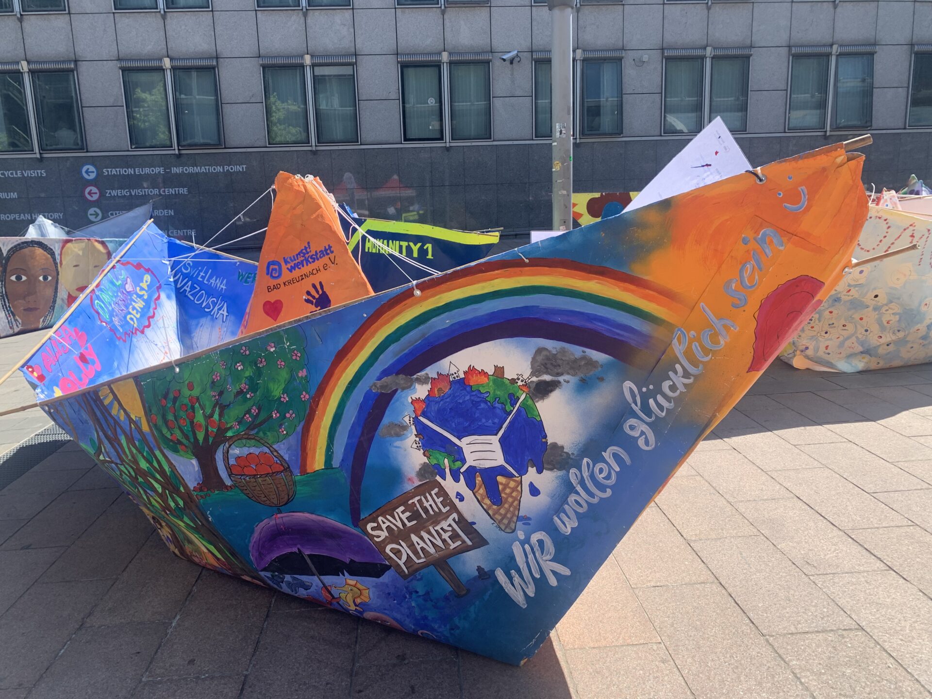 Bild eines der Origami-Boote von #100Boote100MillionenMenschen, bunt bemalt, vor der Europäischen Parlament