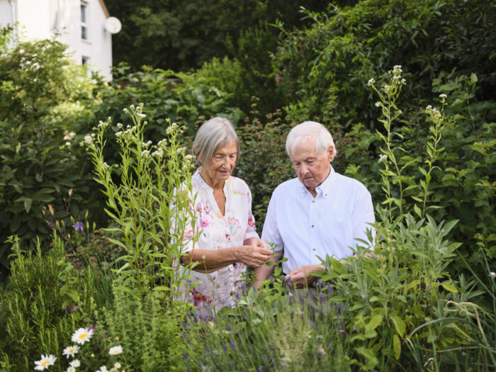 Eine Seniorin und ein Senior im Garten