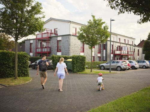 Familie geht zu einem Gebäude