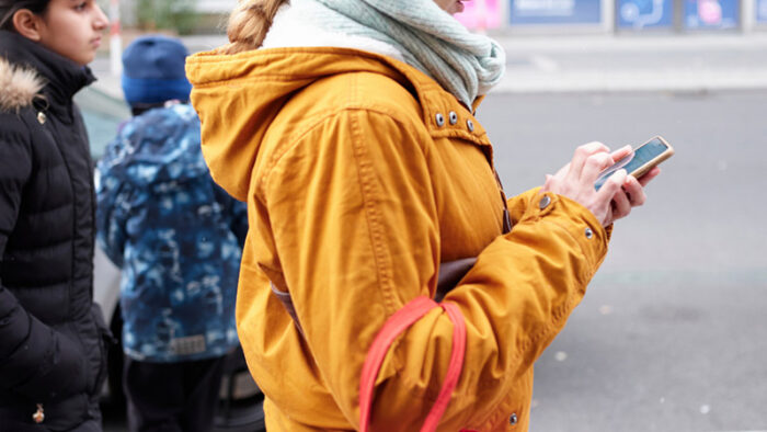 weibliche Person mit Smartphone in der Hand