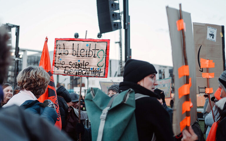Personen auf Demo mit Schild "Wo bleibt die soziale Gerechtigkeit?"