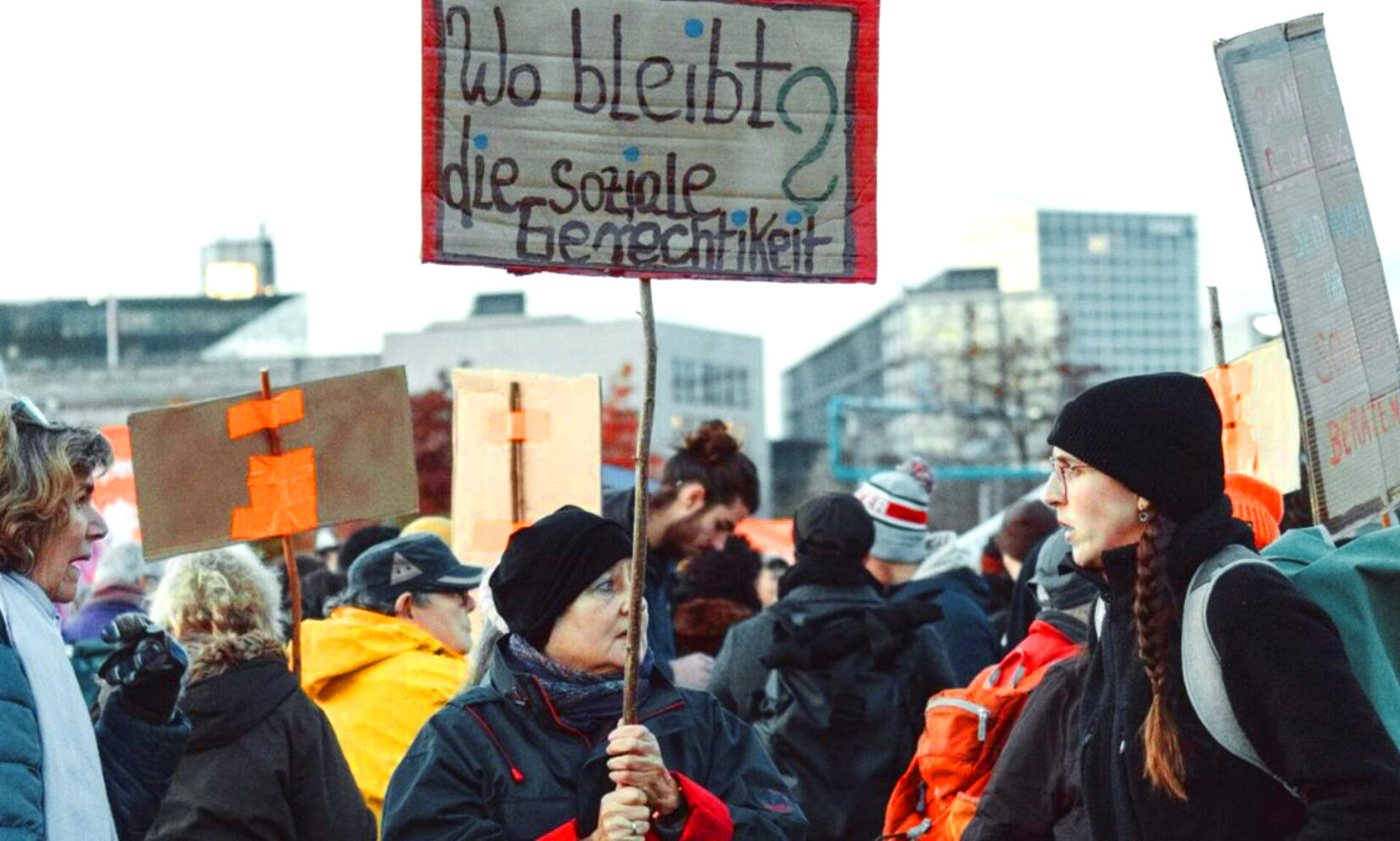 Personen auf Demo mit Schild "Wo bleibt die soziale Gerechtigkeit?"