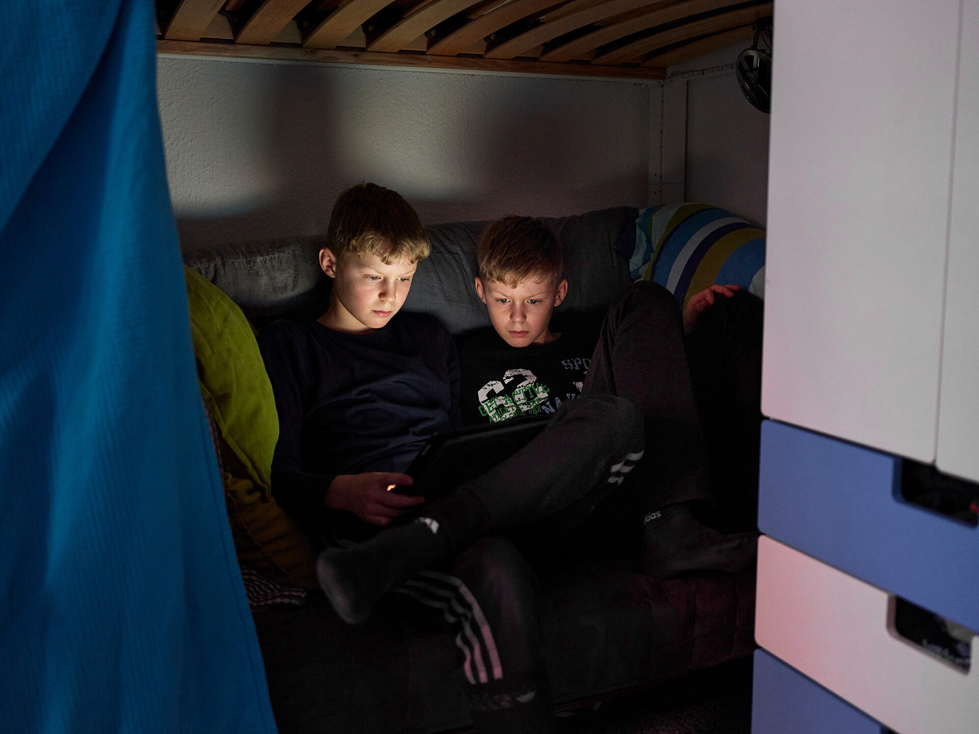 Zwei Teenager sitzen am Tablet.