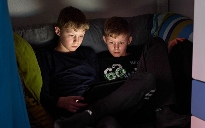 Zwei Teenager sitzen am Tablet.