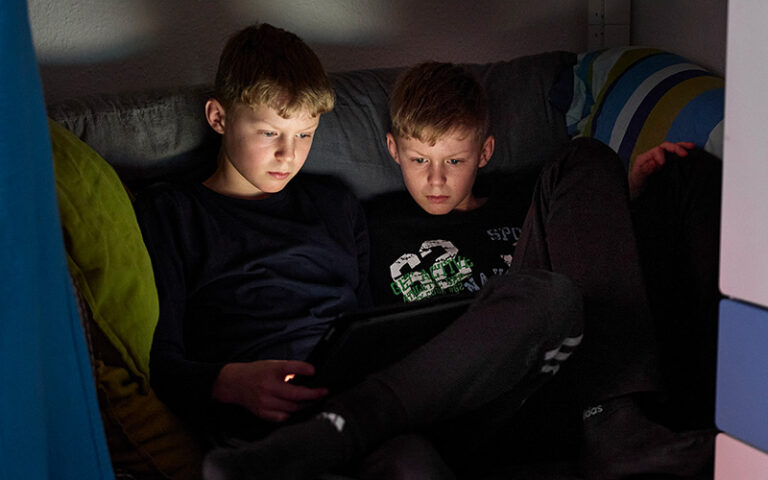 Zwei Teenager sitzen am Tablet.