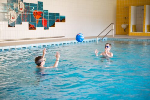 Zwei Jungen spielen Therapiebad der AWO LangeoogKlinik mit einem Ball.