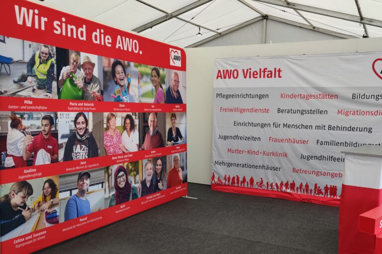Plakat-Wände: "Wir sind die AWO" mit Fotos von Personen und "AWO-Vielfalt" mit Begriffen, die für die Arbeit der AWO stehen