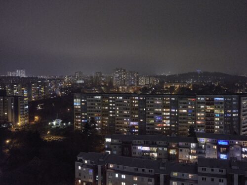 Eine Stadt mit vielen hohen Wohngebäuden bei Nacht.