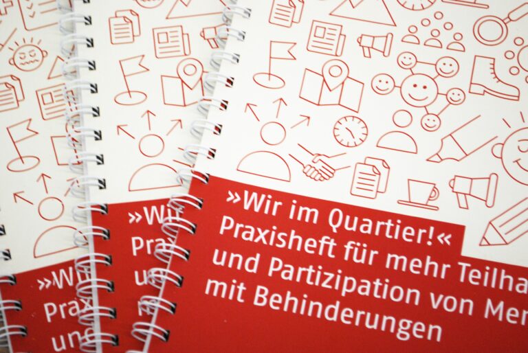 Aufnahme von einem kleinen Stapel Hefte auf denen steht: "Wir im Quartier! Praxisheft für mehr Teilhabe und Partizipation von Menschen mit Behinderung"