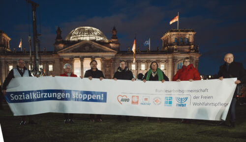 Die Vertreter*innen der BAGFW stehen vor dem Bundestag. Sie halten gemeinsam ein Banner "Sozialkürzungen stoppen! Bundesarbeitsgemeinschaft der Freien Wohlfahrtspflege".